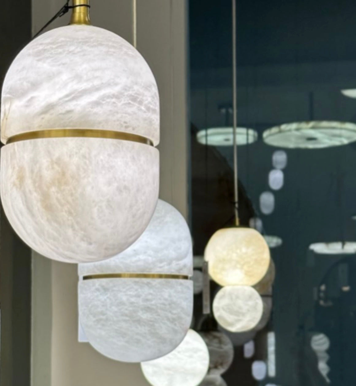 White textured pendant light with gold accents in a showroom setting