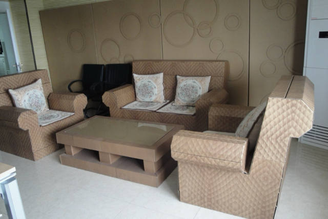 Cardboard furniture set made from Wheat Straw (instead of toxic harmful  chemicals and 30 year old virgin trees) including a sofa and coffee table in a room setting.